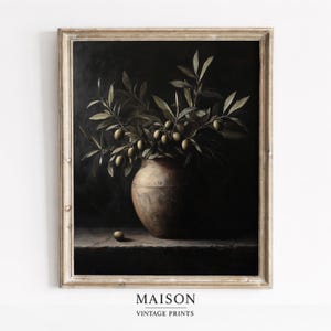 May include: A framed vintage print featuring a still life of olive branches and olives in a rustic bronze vase. The artwork has a dark, moody aesthetic, with the word "MAISON" and "VINTAGE PRINTS" printed at the bottom.
