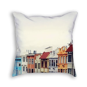 May include: A row of colorful houses with different architectural styles, including a blue house, a red house, and a yellow house. The houses are lined up against a white background.