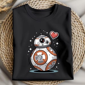 May include: Black crew neck sweatshirt featuring a cartoon illustration of a BB-8 droid with orange and white details, a red heart, and star accents. The design is centered on the front of the shirt.