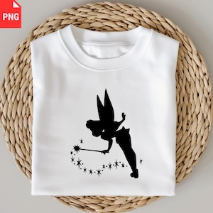May include: White sweatshirt featuring a black silhouette of a fairy with a wand and stars. The fairy is depicted with large wings and a flowing dress. The design is centered on the front of the shirt, creating a whimsical and magical aesthetic.