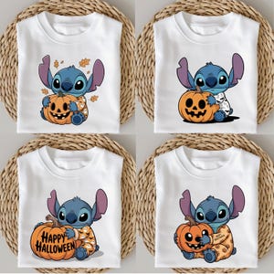 Op de afbeelding: Vier witte t-shirts met een Halloween-thema. Elk shirt heeft een blauw stripfiguur dat een oranje pompoen vasthoudt. Het personage draagt een Halloween-pyjama. Sommige shirts hebben herfstbladeren.