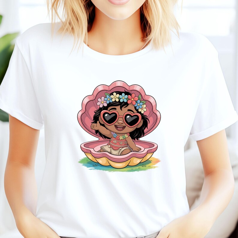 May include: White t-shirt featuring a cartoon illustration of a dark-skinned child wearing heart-shaped sunglasses and a floral crown, seated inside a pink seashell. The child is waving. The seashell rests on a colorful, rainbow-hued base.