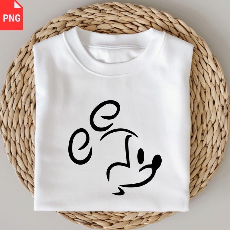 May include: White sweatshirt featuring a black minimalist Mickey Mouse design. The graphic is a simple outline of the character's face and ears. The sweatshirt is folded and placed on a woven, light brown surface.