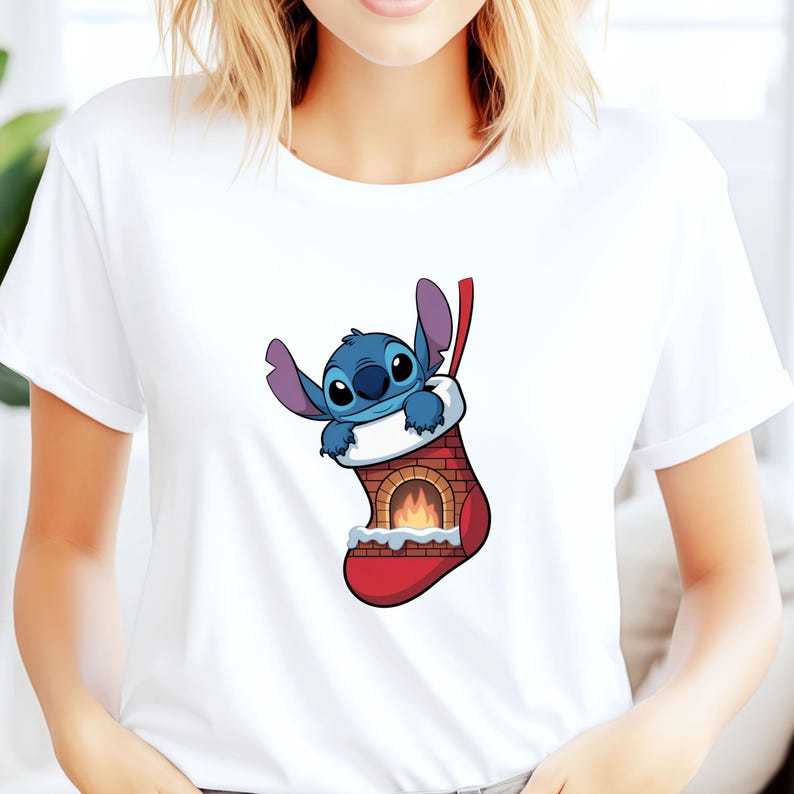 Pu&ograve; includere: T-shirt bianca con un'immagine a cartoni animati di Stitch di Lilo & Stitch. Stitch, un alieno blu, &egrave; all'interno di una calza di Natale rossa con un design a camino. La calza ha un polsino bianco e un nastro rosso.