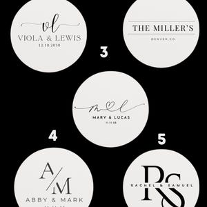 Puede incluir: Una colección de cinco posavasos redondos de color blanquecino con texto negro. Cada posavasos presenta un diseño diferente, incluyendo iniciales, nombres y fechas. Los diseños son elegantes y adecuados para bodas o eventos especiales.