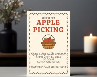 Op de afbeelding: Een crème-kleurige uitnodigingskaart met een geschulpte rand, met de tekst "APPLE PICKING" in het rood. Een mand met appels staat eronder. De kaart vermeldt de datum 14 september 2024 en de tijd 10:00 uur.