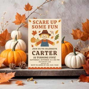 May include: An invitation card with the text "SCARE UP SOME FUN" and "JOIN US TO CELEBRATE CARTER IS TURNING FIVE!" features a scarecrow illustration, pumpkins, and fall leaves. The card is surrounded by pumpkins, pinecones, and autumn foliage.