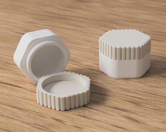 May include: Three white, hexagonal containers are displayed on a wooden surface. One container is open, revealing the interior, while the other is closed. The lids and bases have a ridged design. The containers are likely for storage.