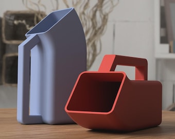 May include: Two modern, minimalist scoops. One is a light blue with a handle, the other is a red-orange with a handle. Both are made of a smooth material and sit on a wooden surface. The scoops have a rectangular opening.