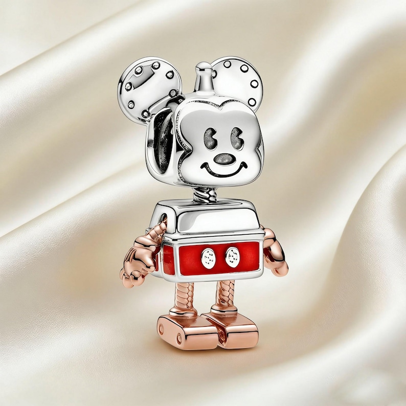 Może przedstawiać: Srebrny i czerwony charms robota Myszki Miki. Charms przedstawia głowę Myszki Miki z okrągłymi uszami i uśmiechniętą twarzą. Korpus jest czerwony z dwoma białymi okręgami, a ramiona i nogi są w kolorze r&oacute;żowego złota.