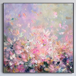 Puede incluir: Gran pintura abstracta cuadrada con marco negro. La obra presenta un diseño floral texturizado en tonos rosa, morado y verde. La pintura cuelga sobre un sofá blanco en un salón moderno.