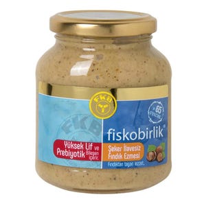 May include: A jar of hazelnut butter with a gold lid and a blue label. The label features the text "fiskobirlik" and "65 Fındık". The jar contains a light brown, creamy spread. The label also includes the words "Yüksek Lif ve Prebiyotik".