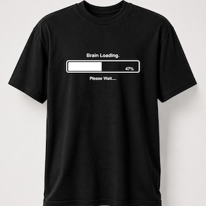 May include: A black short-sleeved t-shirt featuring a white graphic of a loading bar. Above the bar, the text reads Brain Loading. Inside the bar, the number 47% is displayed on the right side. Below the bar, the text reads Please Wait....