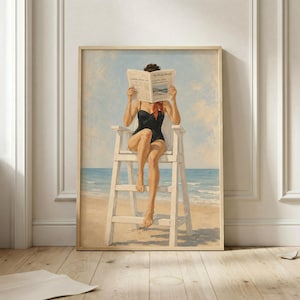 Peut inclure: Une impression d'art mural encadrée représentant une personne en maillot de bain une pièce noir et un foulard rouge assise sur une chaise de sauveteur en bois blanc à la plage. La personne tient un journal ouvert intitulé The Daily Herald devant son visage.