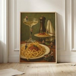 May include: A framed art print depicting a surreal scene with miniature figures interacting with a large stemmed glass, a dark wooden pepper mill, a white cloth, and two plates of spaghetti with red sauce, all set against a dark green background.