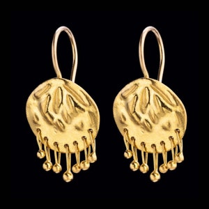 May include: A pair of gold dangle earrings with a textured round disc and a fringe of small gold balls.