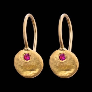 May include: A pair of gold earrings with a small pink gemstone in the centre of each earring.