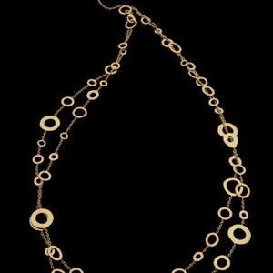 May include: A gold necklace with a double strand of chain and large, uneven, circular links.