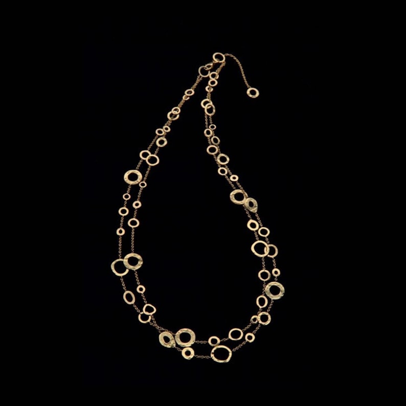 May include: A gold necklace with a delicate chain and multiple round, textured pendants.