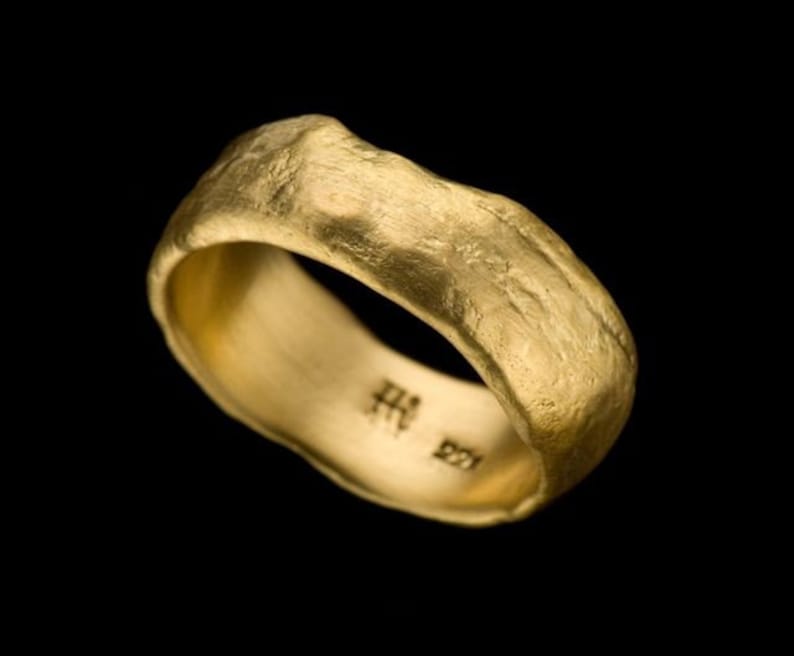 Puede incluir: Un anillo de banda de oro con un acabado texturizado martillado. El interior de la banda est&aacute; estampado con "HH 221".
