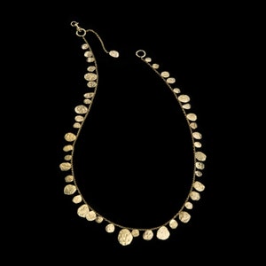 May include: A gold necklace with a delicate chain and multiple small, hammered, round pendants.
