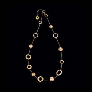 May include: A gold necklace with a chain and multiple hammered gold circles of varying sizes.