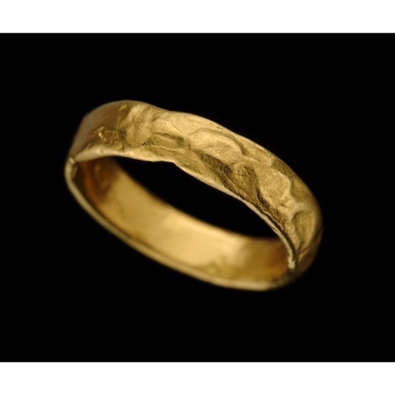 May include: A simple gold band ring with a textured, hammered finish.
