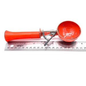 Op de afbeelding: Een ijslepel met een oranje kunststof handvat en een metalen kom. De lepel is 17,8 cm lang en heeft een metalen handvat met een draaimechanisme.