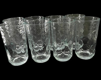 May include: Set of six clear glass tumblers with a textured, bubbled surface. The glasses are empty and arranged in a row.