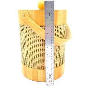 May include: A wooden ice bucket with a woven design and a leather handle. The bucket is 12 inches tall.