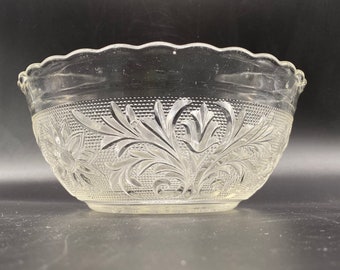 May include: A clear glass bowl with a scalloped rim and an intricate floral pattern etched into the surface.