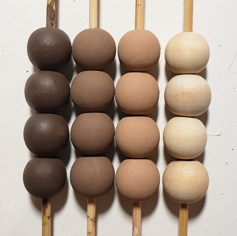 May include: Three rows of wooden beads on sticks. The top row is dark brown, the middle row is light brown, and the bottom row is light beige.