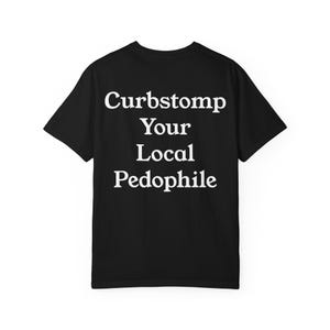 Puede incluir: Camiseta negra con el texto blanco "Curbstomp Your Local Pedophile" impreso en la espalda. La camiseta es de estilo cuello redondo, con mangas cortas. El texto está centrado y en negrita, con fuente sans-serif.