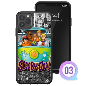 K&ouml;nnte beinhalten: Schwarze Handyh&uuml;lle mit der Mystery Machine von Scooby-Doo und der Scooby-Doo-Gang. Die H&uuml;lle hat einen Comic-Hintergrund und die Worte "Scooby-Doo!" in Lila und Gelb. Neben der H&uuml;lle liegt ein schwarzes Telefon.
