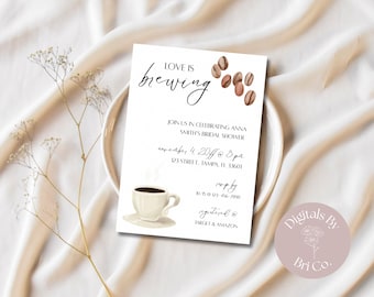 May include: A white invitation card with the text "Love is Brewing" and coffee-themed illustrations. The card includes details for a bridal shower, featuring a coffee cup, coffee beans, and the text "registered @ Target & Amazon."