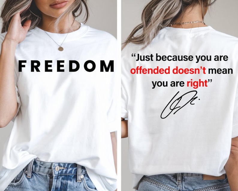 Puede incluir: Camiseta blanca con la palabra "FREEDOM" en letras negras grandes en la parte delantera. La parte posterior de la camiseta presenta la cita, "Just because you are offended doesn't mean you are right" en negro y rojo.
