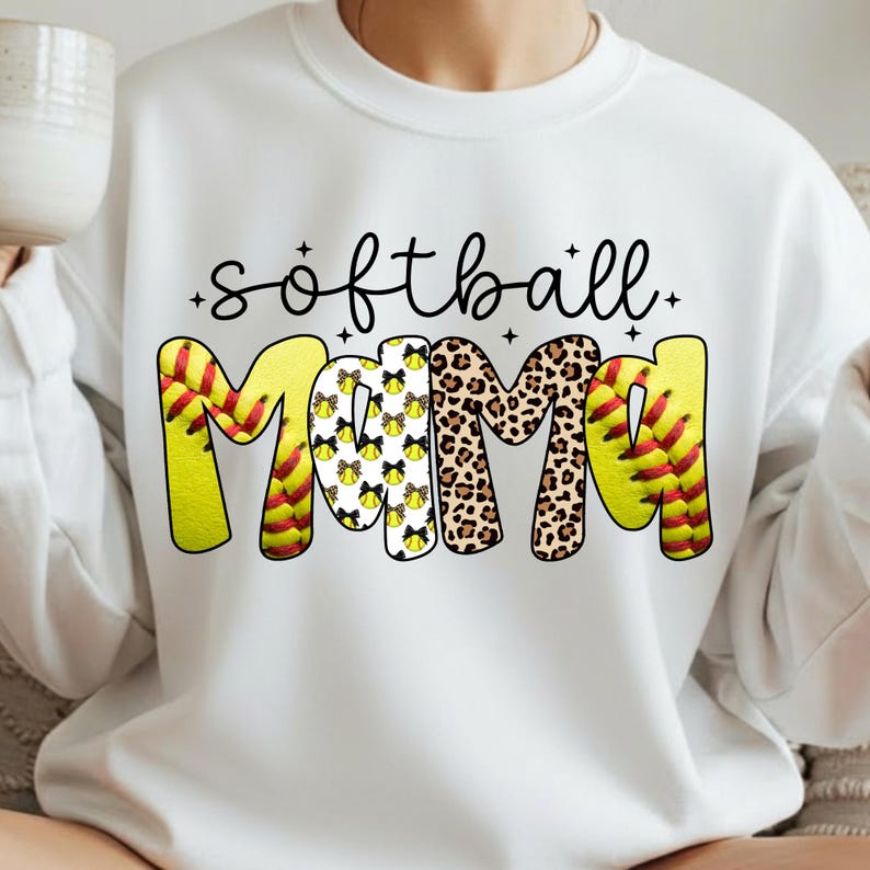 May include: White sweatshirt with the words "softball Mama" in black script and bold letters. The word "Mama" is designed with a softball, leopard print, and softball bow pattern. The sweatshirt is a casual style.