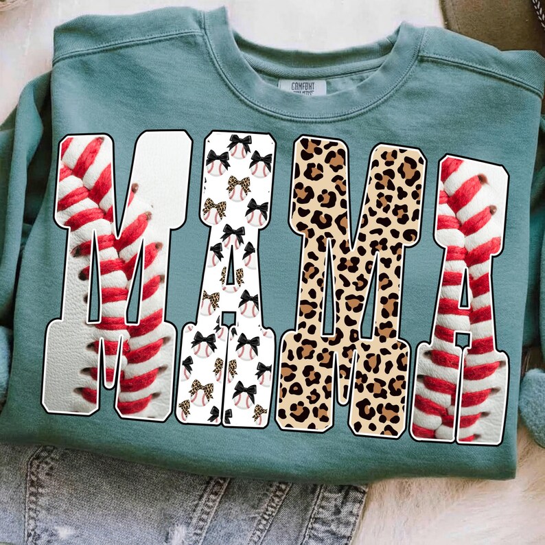May include: Teal sweatshirt with the word "MAMA" in large, bold letters. The "M"s are baseballs with red stitching, the "A"s are baseballs with bows, and the middle "M" is leopard print.