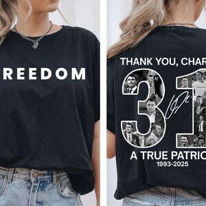 May include: Black t-shirt with the word "FREEDOM" in white block letters on the front. The back of the shirt features the text "THANK YOU, CHARLIE." with the number "31" and the words "A TRUE PATRIOT 1993-2025".