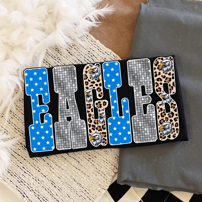 May include: Black rectangular design with the word "EAGLES" in a bold, block letter style. The letters are in blue with white stars, a leopard print, and a silver mosaic pattern. Eagle head graphics are incorporated.