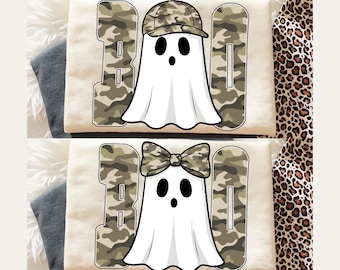 Op de afbeelding: Twee crèmekleurige sweatshirts met een Halloween-thema. Elk shirt heeft een witte geest met zwarte ogen en een mond, met een camouflage hoed of strik. Het woord "BOO" is in camouflage gedrukt.
