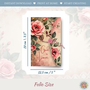 Op de afbeelding: Een rechthoekige papieren folio met een vintage bloemendesign van roze rozen, groene bladeren en een kleine vlinder. De tekst luidt God is Love. Een roze knoopsluiting met touwtje is zichtbaar. De afmetingen zijn 19 cm bij 12,5 cm.
