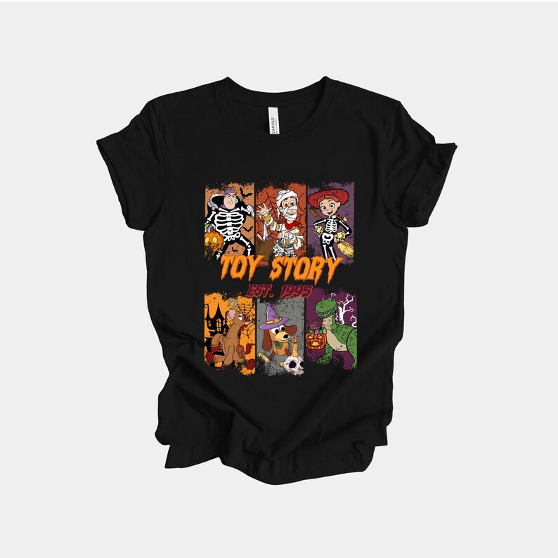 May include: Black t-shirt featuring a Halloween-themed graphic with characters from Toy Story. The design includes characters dressed in costumes, the words "Toy Story" and "Est. 1995".
