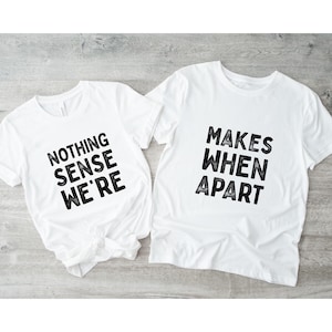 May include: Two white t-shirts with black text. One shirt reads "NOTHING SENSE WE'RE" and the other reads "MAKES WHEN APART". The shirts are short-sleeved and appear to be made of cotton.