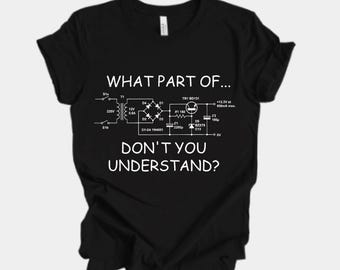 Puede incluir: Camiseta negra con texto blanco y un diagrama de circuito. El texto dice "WHAT PART OF... DON'T YOU UNDERSTAND?" El diagrama incluye componentes electrónicos, ideal para entusiastas de la electrónica.