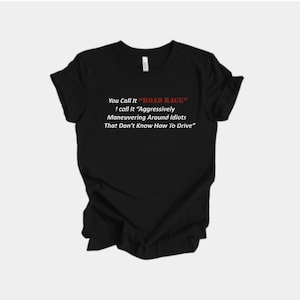 May include: Black t-shirt with white text that reads "You Call It 'ROAD RAGE' I call It 'Aggressively Maneuvering Around Idiots That Don't Know How To Drive'". The text is in a sans-serif font.