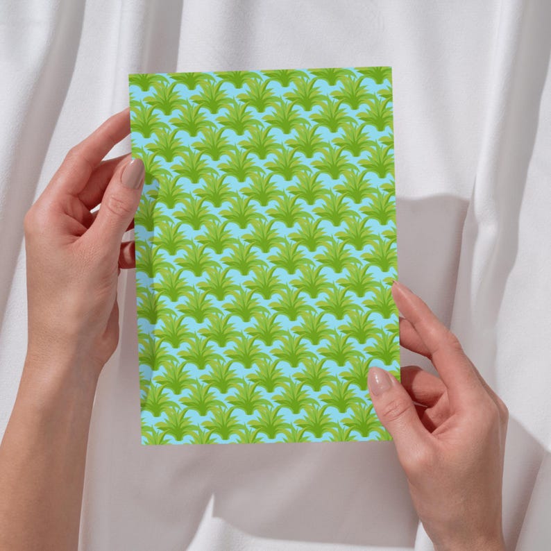 May include: A rectangular card featuring a repeating pattern of stylized green palm-like plants arranged in rows against a light blue background. The design consists of multiple identical botanical shapes evenly spaced across the entire surface.