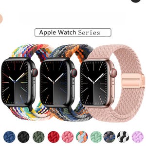 May include: Three Apple Watch Series smartwatches with different coloured braided bands. The watch faces are black with white hands. The bands are rainbow, blue and orange, and pink. The text "Apple Watch Series" is above the watches.