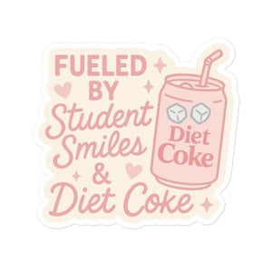 May include: A sticker with a light pink design. The text reads "Fueled by Student Smiles & Diet Coke" in a mix of fonts. A pink soda can with a straw is on the right. The can has the words "Diet Coke" on it.
