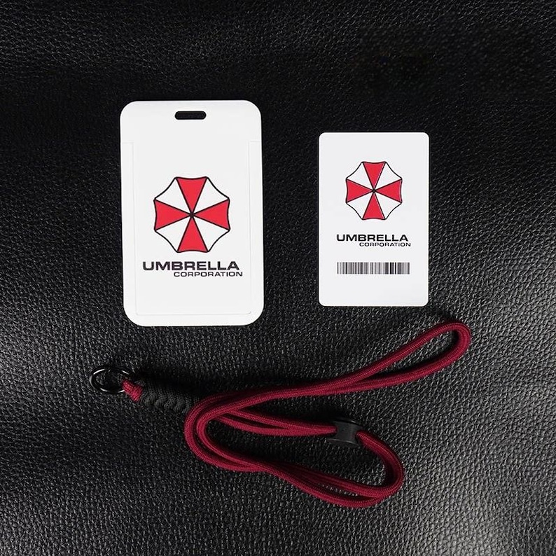 White Umbrella badge holder with inner card and red rope lanyard on leather background, cosplay ID case.